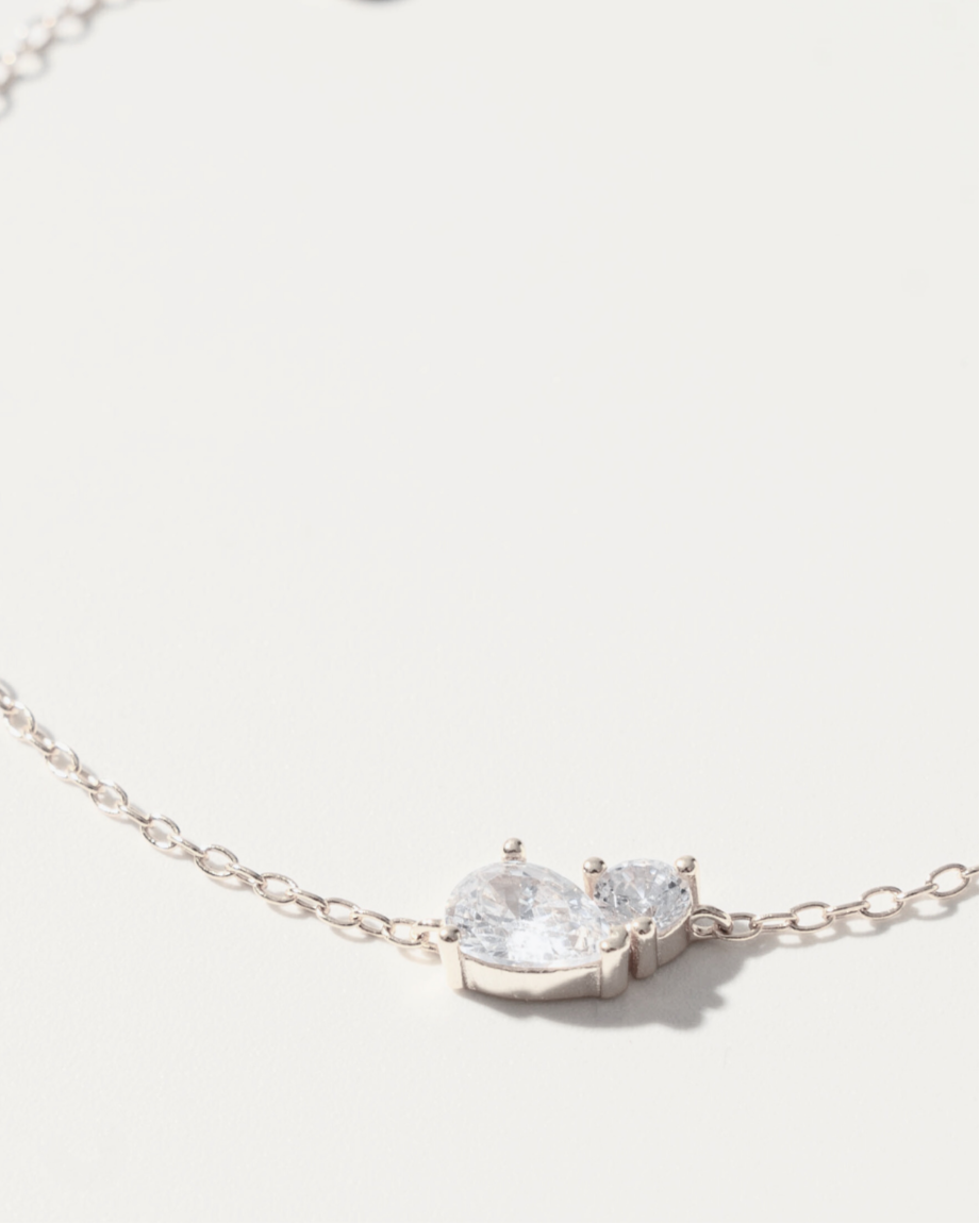 Silver bracelet with a clear gemstone on a light gray background