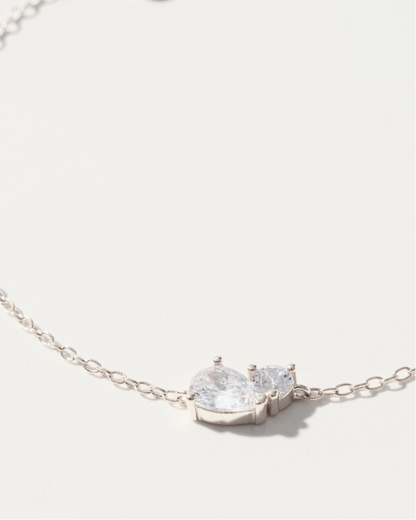 Silver bracelet with a clear gemstone on a light gray background